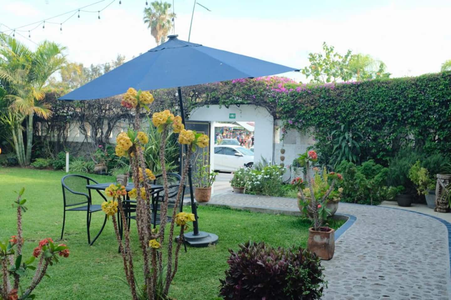 El jardín con sombrilla y mesas